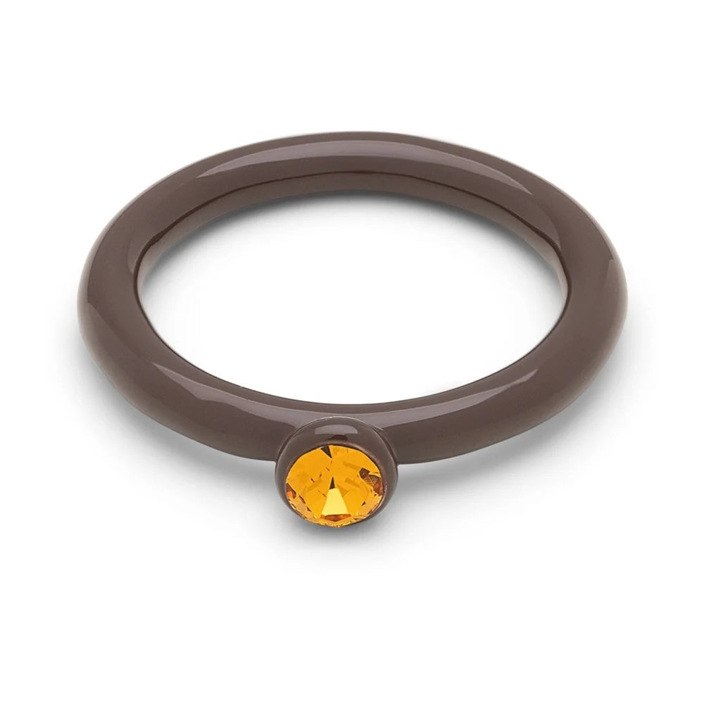 Gele kleur ring gemaakt van kristal met cacao poeder, elegant accessoire van het merk LULU, glanzend en gedetailleerd zichtbaar.