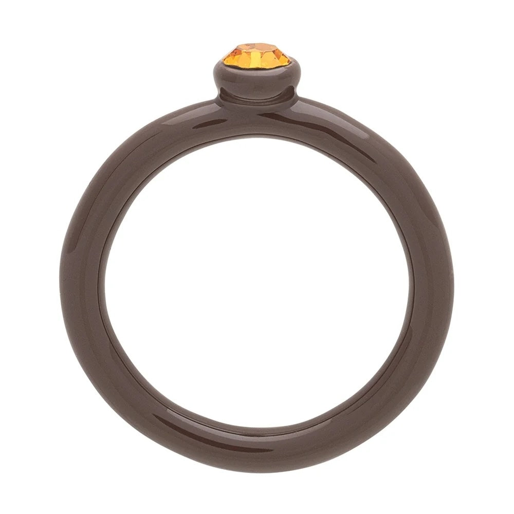 Kristallen kleurring en cacao poeder van LULU, close-up van kleurrijke ring en cacao poeder in potje.