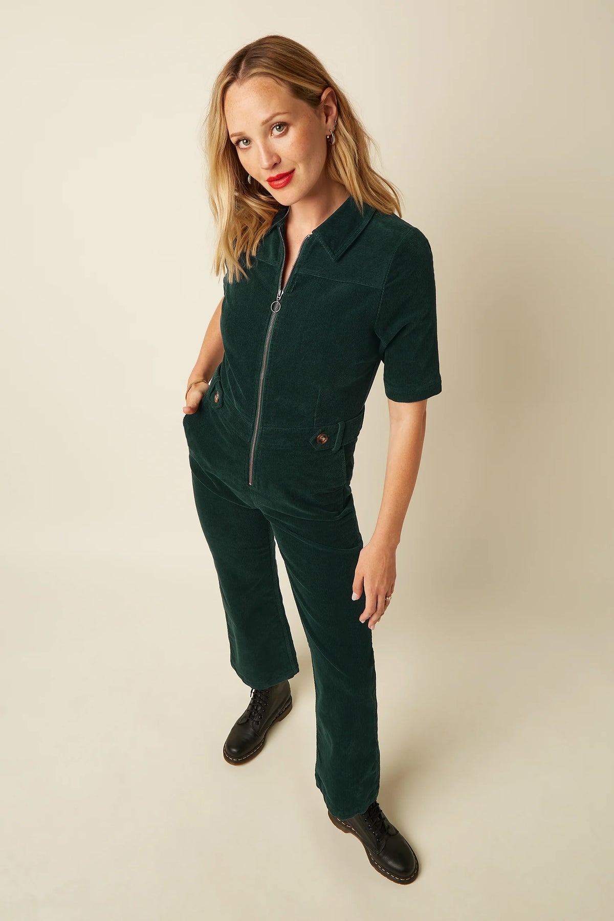Groene corduroy jumpsuit van King Louie met wijde pijpen en knoopsluiting, gedragen door een model op de foto.