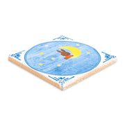 Decoratieve tegel van 10x10cm met maan en sterrenmotief uit de serie In de Maneschijn door StoryTiles, in zachte blauwe tinten.