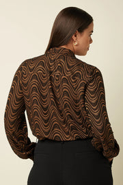 Zwarte Maisie blouse van King Louie met Jackie Jaxquard patroon, getoond op een vrouwelijk model.