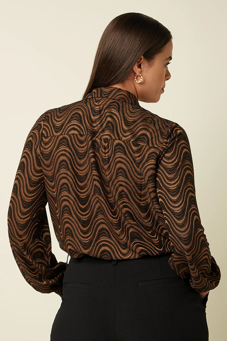 Zwarte Maisie blouse van King Louie met Jackie Jaxquard patroon, getoond op een vrouwelijk model.