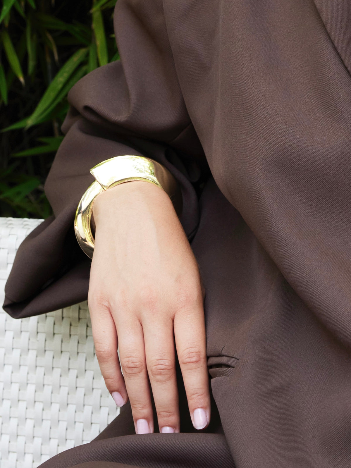 Goudkleurig plat organisch scharnierarmband van Ellen Beekmans met een glad, modern design en natuurlijke vormen.